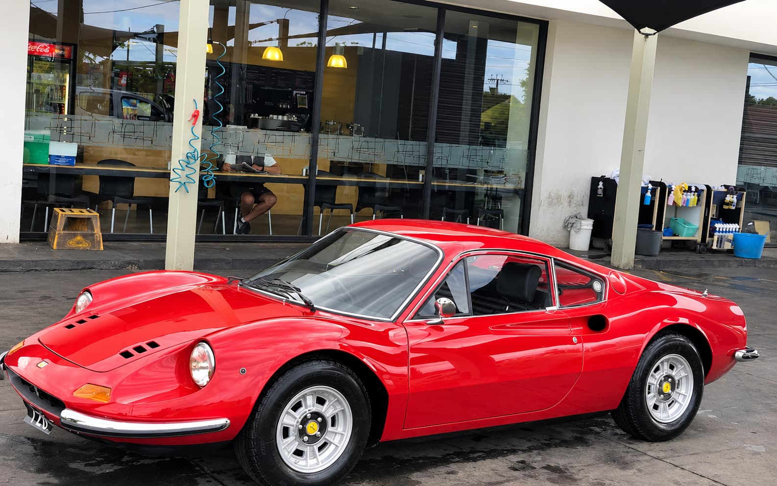 A classic car parked outside the Bubbles cafe windows